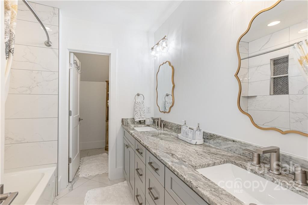 112 Meadow Breeze Road Arden, NC 28704 - Photo 30 of 44 a bathroom with a granite countertop sink a mirror and shower