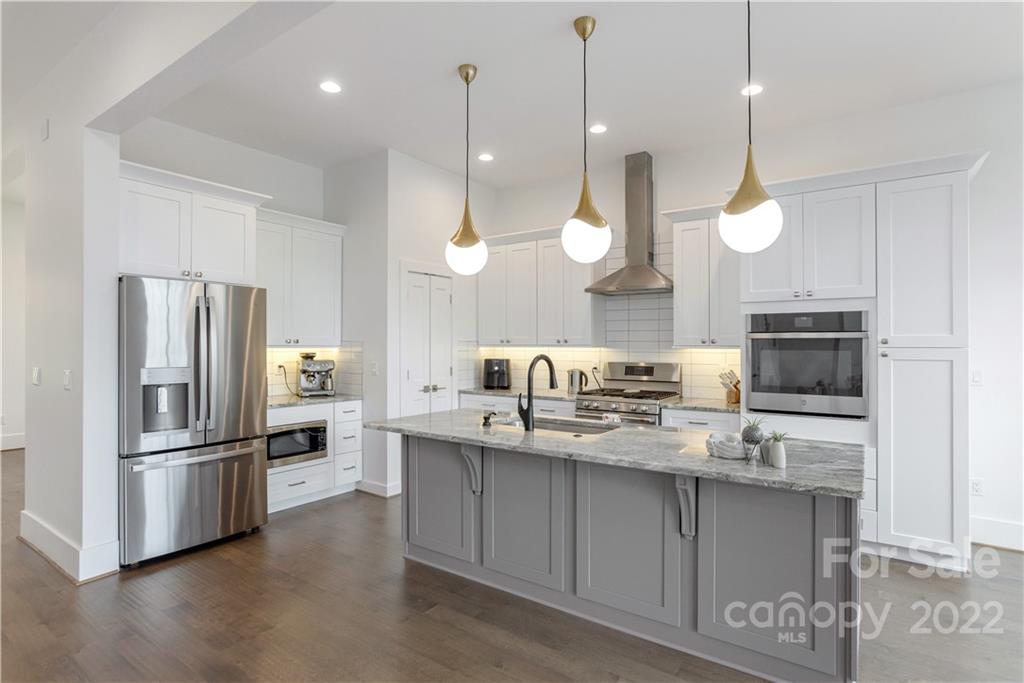 112 Meadow Breeze Road Arden, NC 28704 - Photo 10 of 44 a kitchen with kitchen island granite countertop a sink a center island a refrigerator and wooden floor