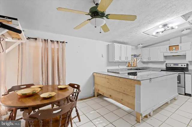 a kitchen with stainless steel appliances granite countertop a sink a stove a dining table and chairs