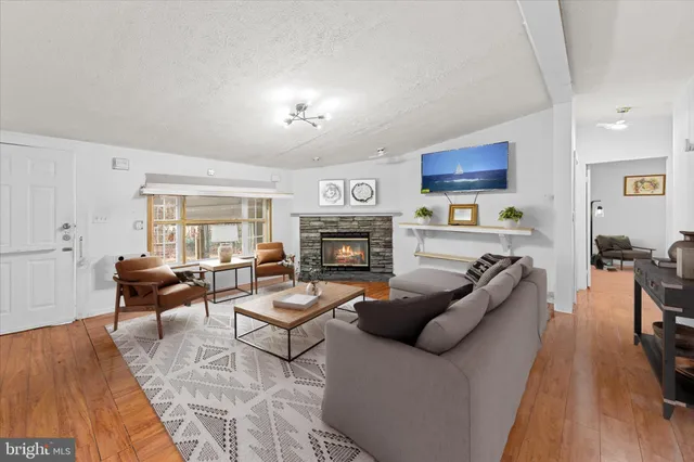 a living room with furniture a fireplace and a wooden floor