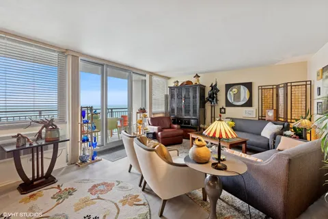 a living room with furniture a flat screen tv and a floor to ceiling window