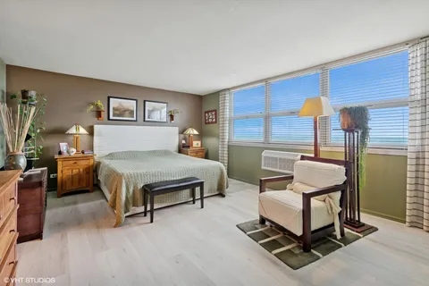 a bedroom with a bed a table and painting on the wall