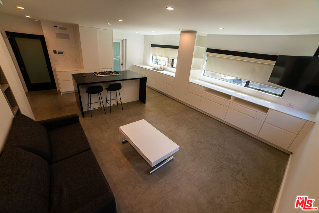 14 Brooks Avenue, Unit 8 Venice, CA 90291 - Photo 7 of 13 a living room with stainless steel appliances furniture a rug and a kitchen view