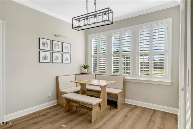 a view of a white house next to a yard with potted plants