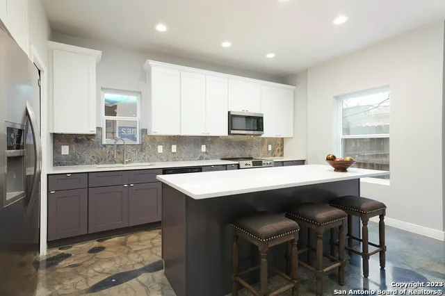 a kitchen with stainless steel appliances stove a sink and a refrigerator