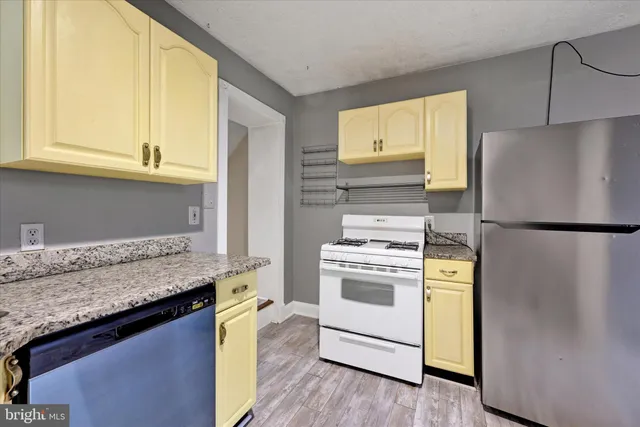 a kitchen with stainless steel appliances granite countertop a refrigerator and a stove