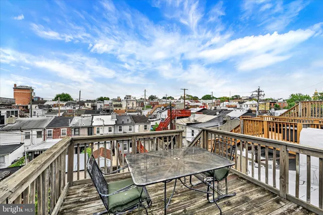a view of a balcony with wooden chairs