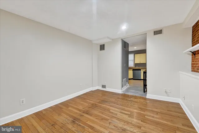 a view of empty room with wooden floor