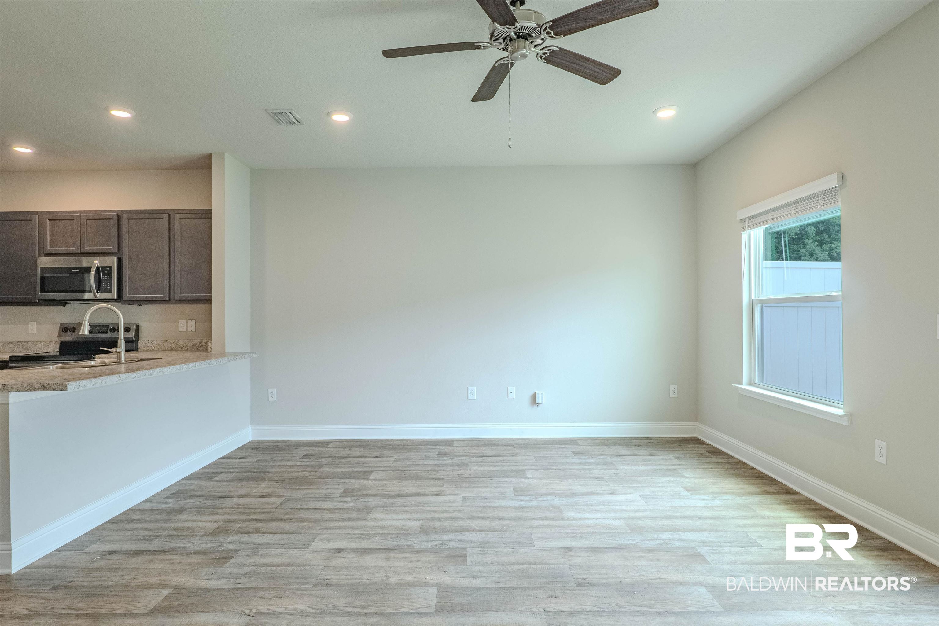 25806 Pollard Road, Unit 32 Daphne, AL 36526 - Photo 8 of 23 Kitchen with dark brown cabinets, light wood-type flooring, electric stove, and ceiling fan