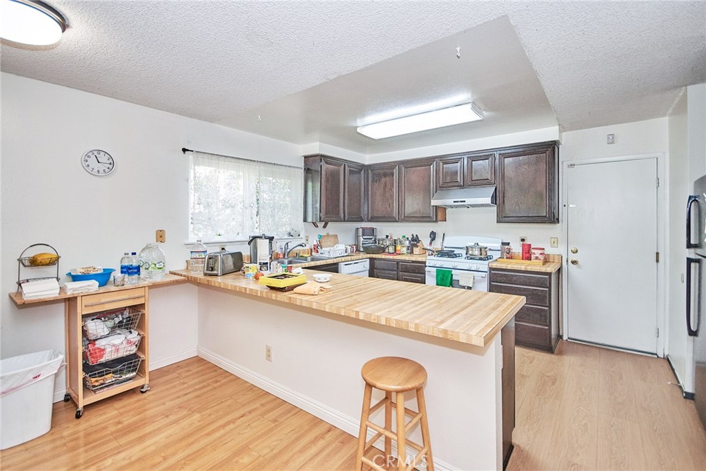 20309 East Vejar Road Walnut, CA 91789 - Photo 12 of 29 a kitchen with stainless steel appliances a sink a stove a refrigerator cabinets and a dining table