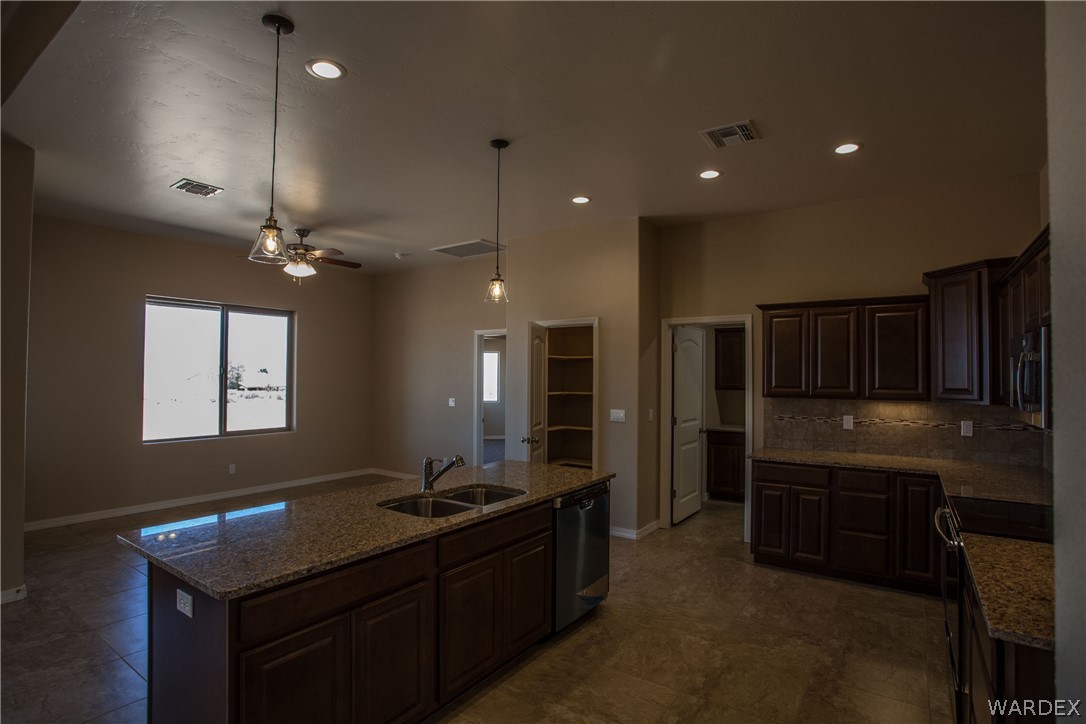 4861 North Neal Ranch Road Kingman, AZ 86401 - Photo 11 of 36 a kitchen with kitchen island granite countertop a sink stainless steel appliances and cabinets
