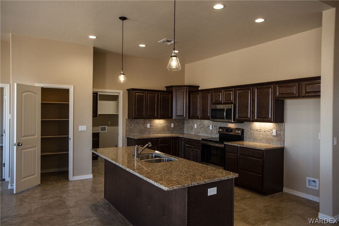 4861 North Neal Ranch Road Kingman, AZ 86401 - Photo 13 of 36 a kitchen with kitchen island sink stove and refrigerator