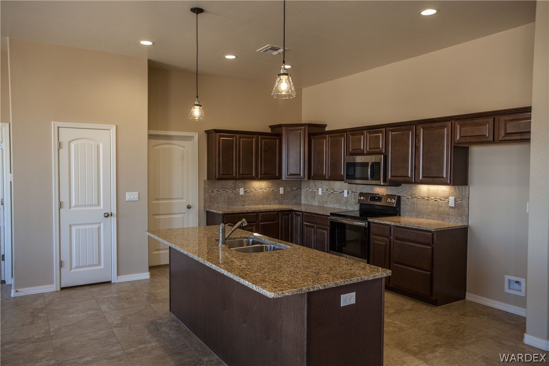 4861 North Neal Ranch Road Kingman, AZ 86401 - Photo 15 of 36 a kitchen with stainless steel appliances granite countertop a sink stove and refrigerator