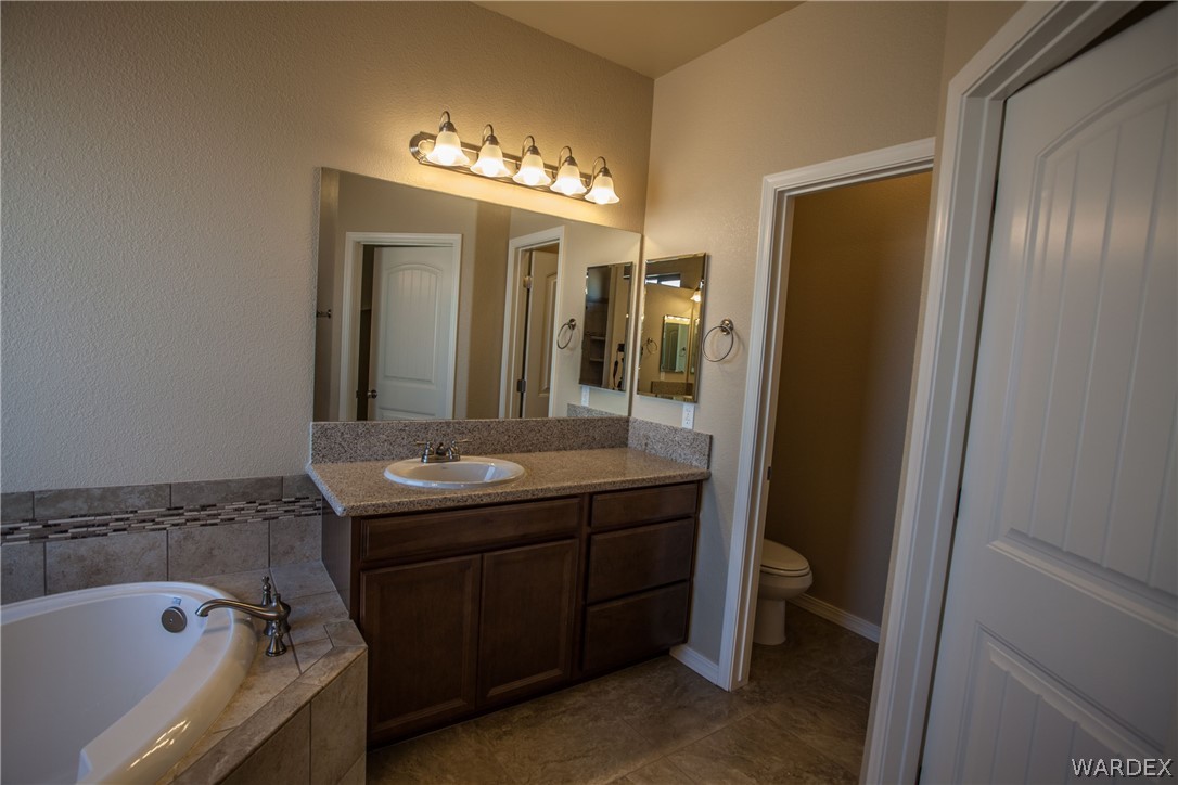 4861 North Neal Ranch Road Kingman, AZ 86401 - Photo 28 of 36 a bathroom with a granite countertop sink toilet and shower