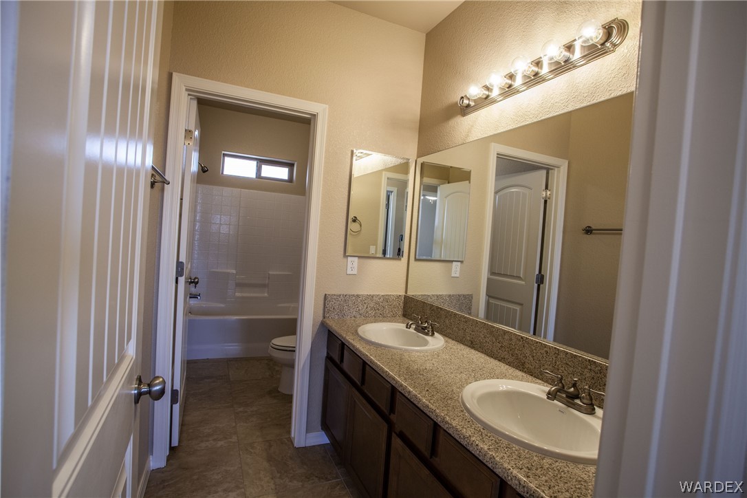 4861 North Neal Ranch Road Kingman, AZ 86401 - Photo 35 of 36 a bathroom with a granite countertop sink shower and a mirror