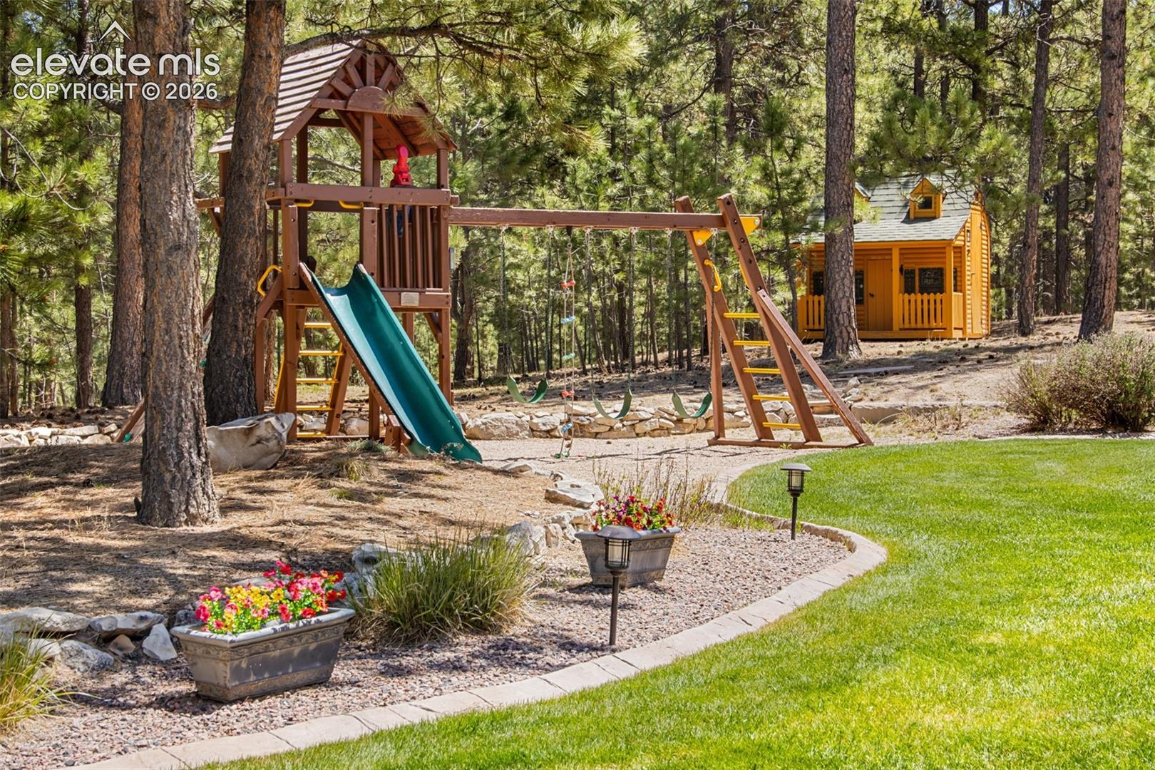 16075 Winding Trail Road Colorado Springs, CO 80908 - Photo 14 of 49 Backyard play area with play set and play house