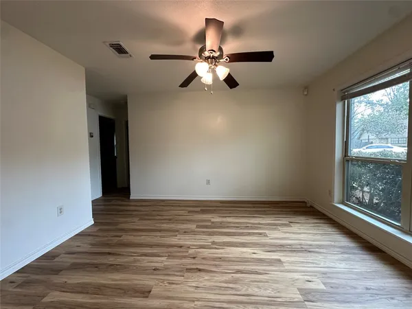 a view of empty room with wooden floor