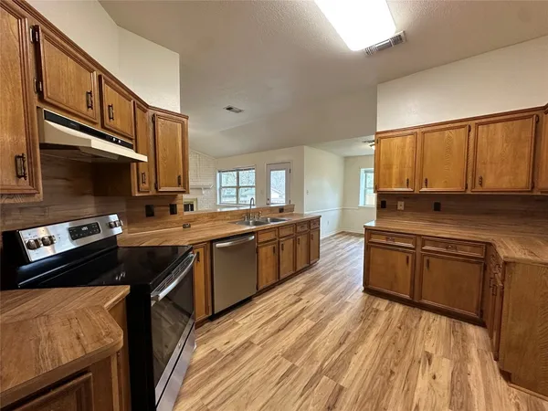 a kitchen with a sink stove and cabinets