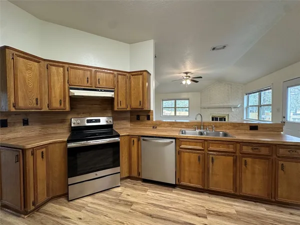 a kitchen with a refrigerator sink and cabinets