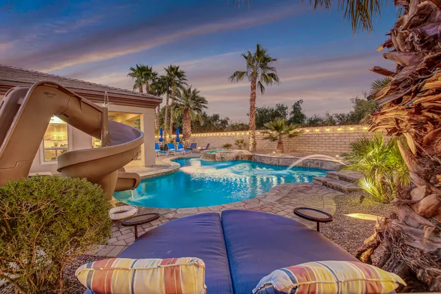 a view of a backyard with plants and swimming pool