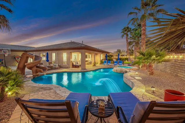 a view of a house with swimming pool and sitting area