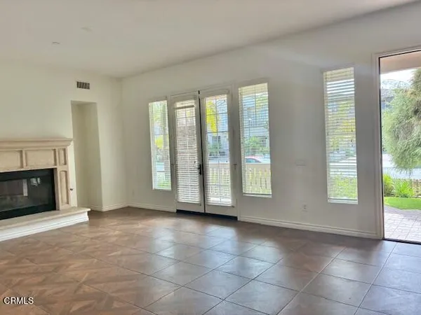 a view of an empty room with a fireplace and a window