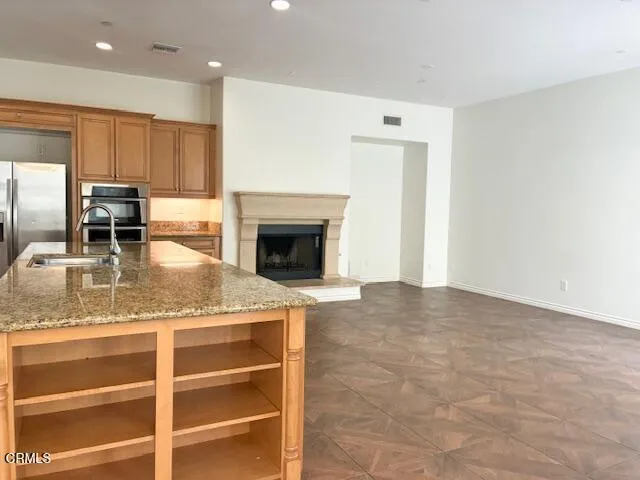 a living room with granite countertop furniture a fireplace and kitchen view