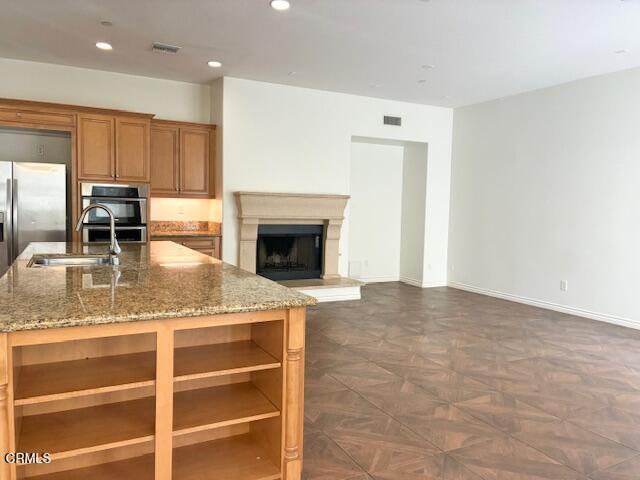 4153 Caribbean Street Oxnard, CA 93035 - Photo 5 of 22 a living room with granite countertop furniture a fireplace and kitchen view