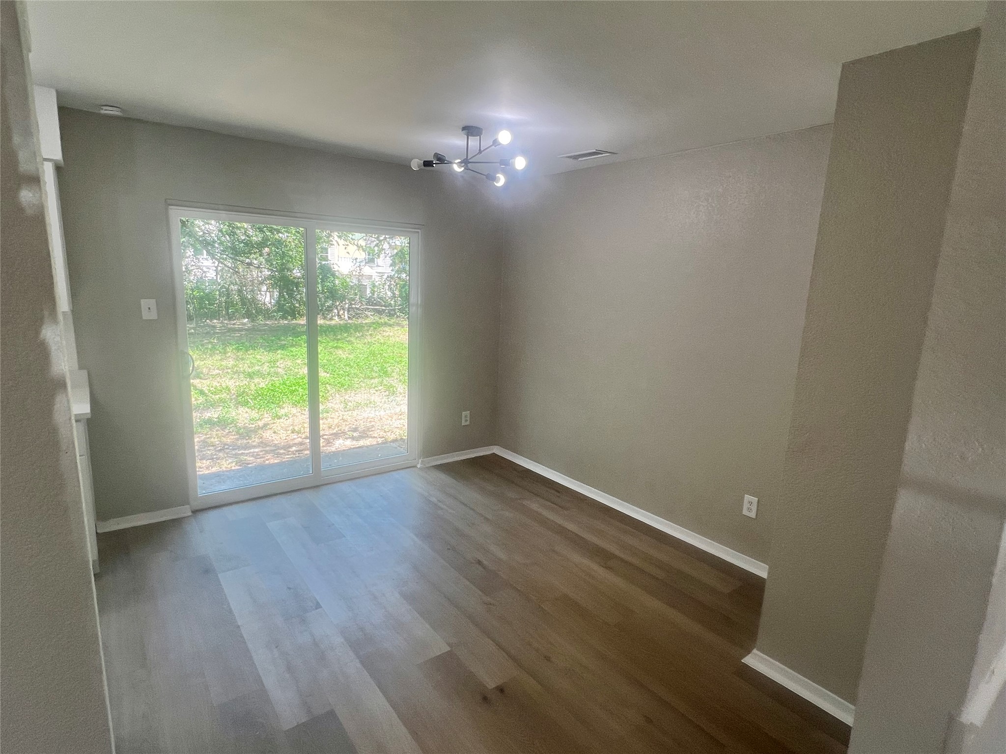 4620 Button Bend Road Austin, TX 78744 - Photo 5 of 22 Sliding glass doors open to a private yard with ample green space.