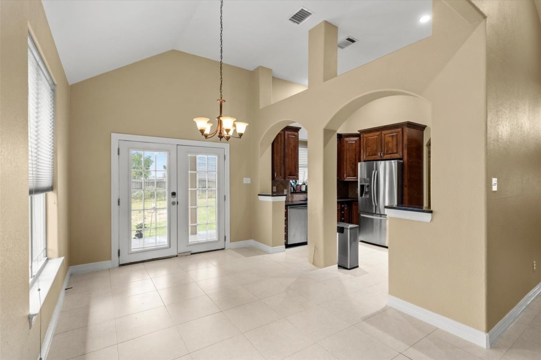 437 Balch Road Elgin, TX 78621 - Photo 7 of 37 A well-lit dining area features a high vaulted ceiling and direct backyard access.