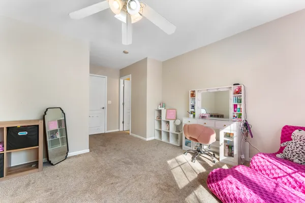 a bedroom with bed and a chandelier fan
