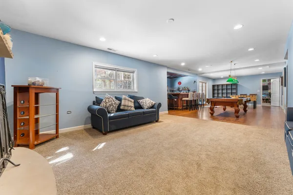 a living room with furniture and a dining table with bookshelf