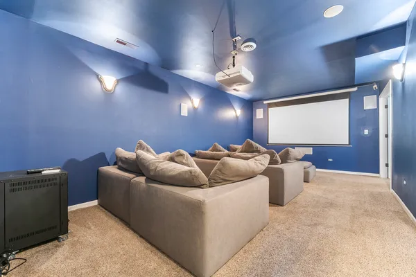 a living room with furniture a chandelier and a projector