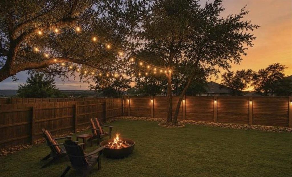 4420 Ingram Road Georgetown, TX 78628 - Photo 29 of 40 Mature trees shade a grassy lawn enclosed by a wooden privacy fence.