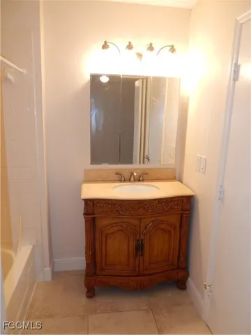 a spacious bathroom with a granite countertop sink and a bathtub