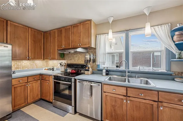 a kitchen with stainless steel appliances granite countertop a sink stove and cabinets