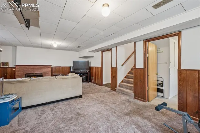 a living room with furniture a refrigerator and a large window