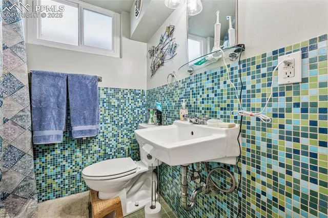 a bathroom with a sink a toilet and shower curtain