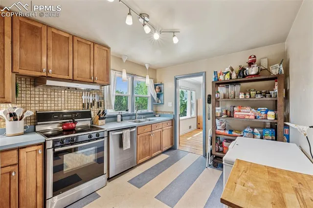 a kitchen with stainless steel appliances a stove a sink dishwasher and cabinets with wooden floor