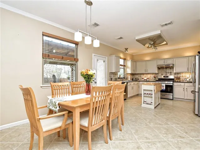 a view of a dining room and livingroom with furniture wooden floor a chandelier