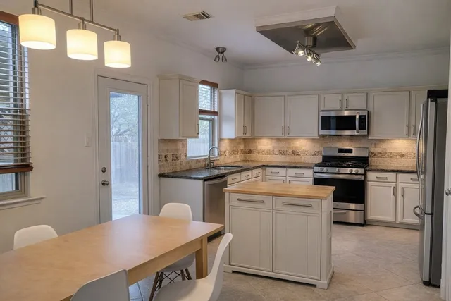 a kitchen with cabinets appliances and a window