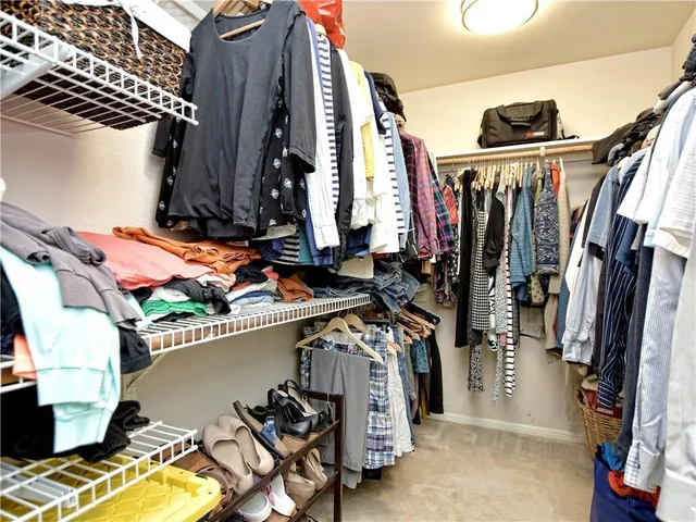 a view of walk in closet with clothes and shoes
