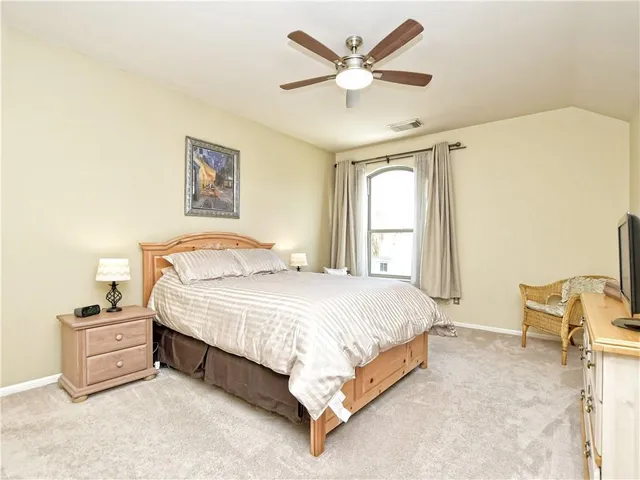 a spacious bedroom with a bed and a window