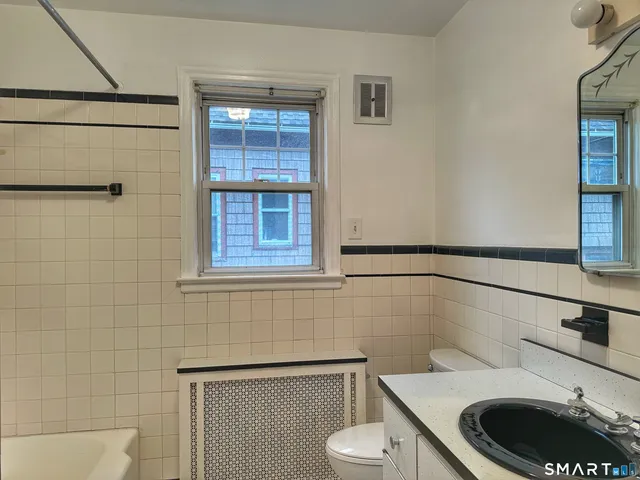 a bathroom with a toilet a sink and mirror