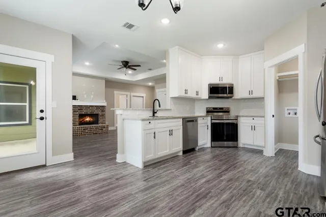 a kitchen with white cabinets and stainless steel appliances