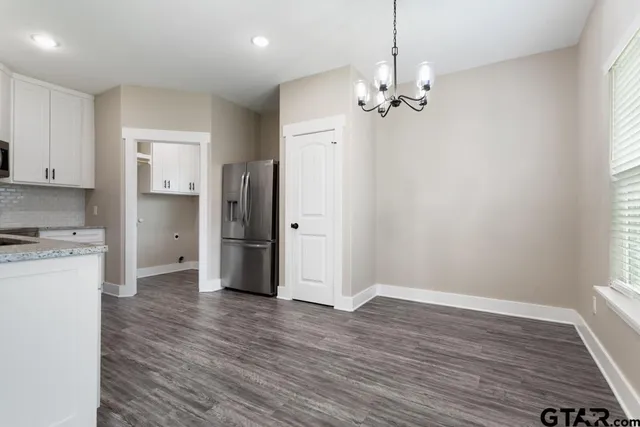 a view of a kitchen with a sink dishwasher a refrigerator and wooden floor