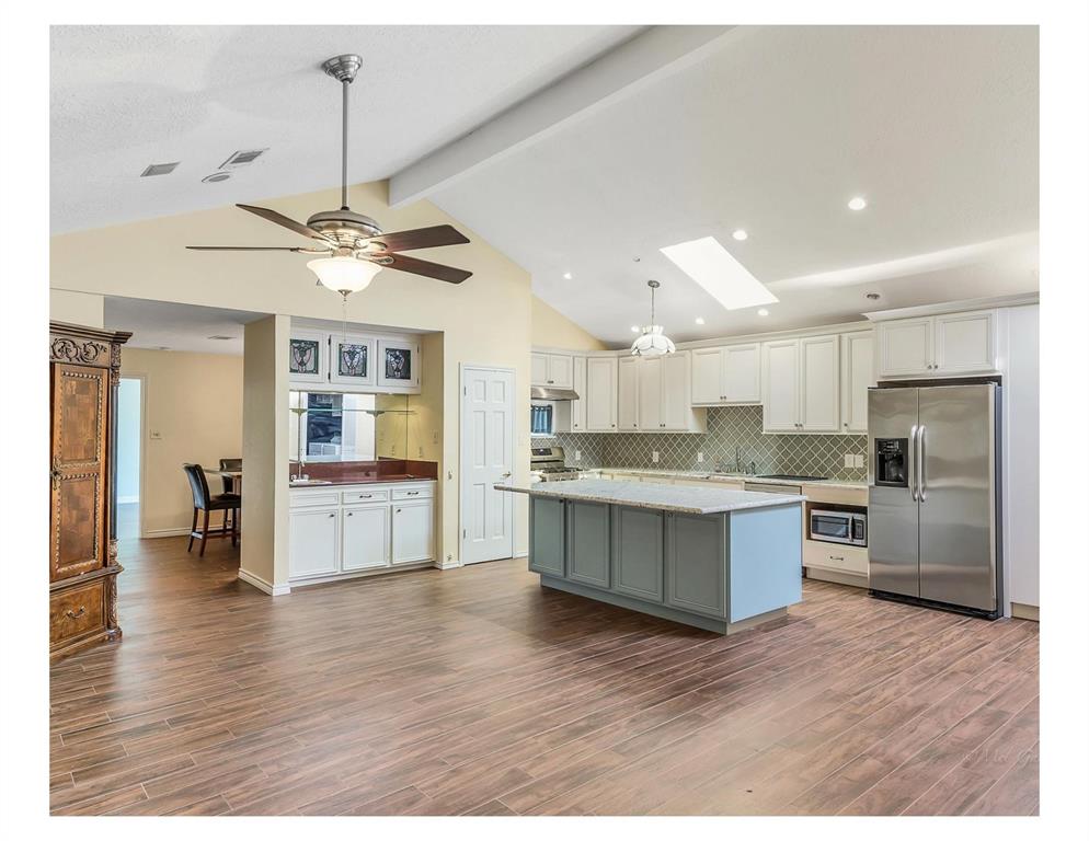 a kitchen with stainless steel appliances kitchen island hardwood floor and stove