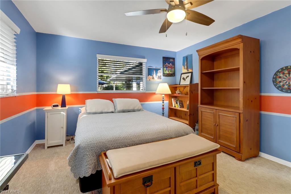 1999 Alamanda Drive Naples, FL 34102 - Photo 14 of 24 a bedroom with a bed and a chandelier