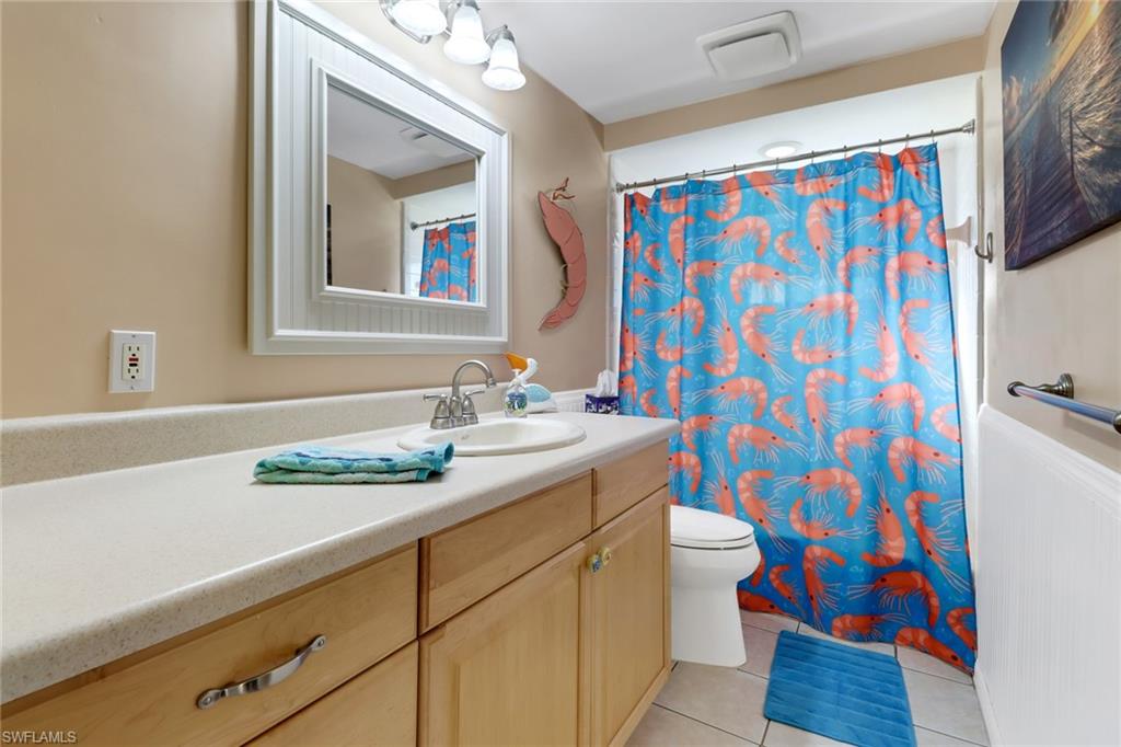 1999 Alamanda Drive Naples, FL 34102 - Photo 15 of 24 a bathroom with a sink a toilet and shower curtain