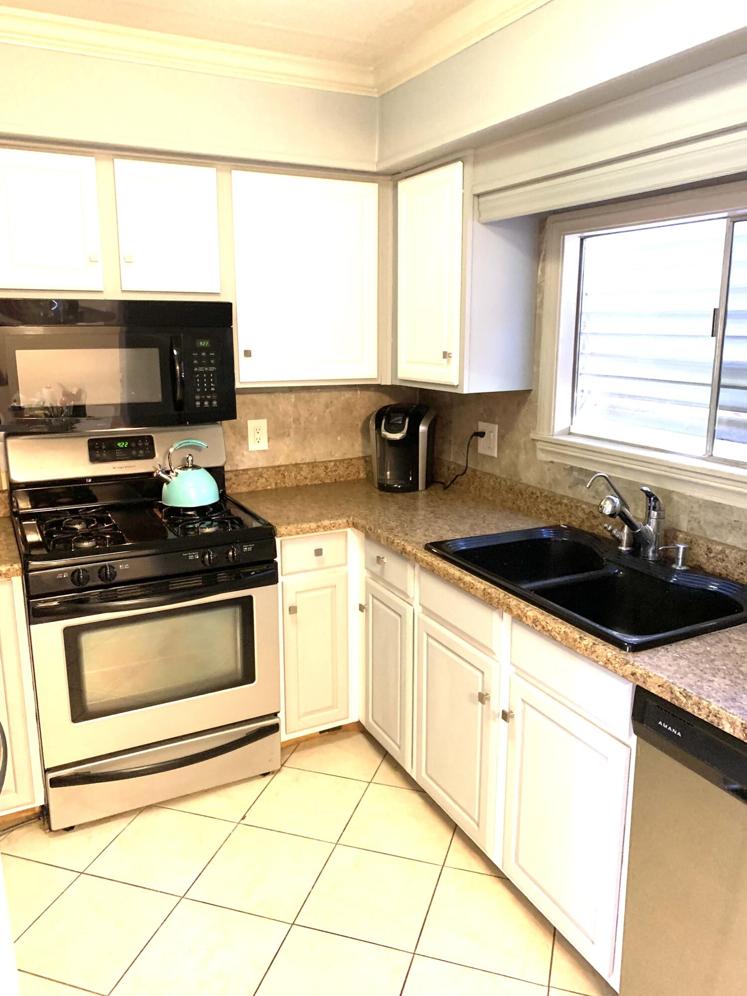 169 Tanforan Rancho Mirage, CA 92270 - Photo 4 of 19 a kitchen with stainless steel appliances a stove a sink a microwave and cabinets